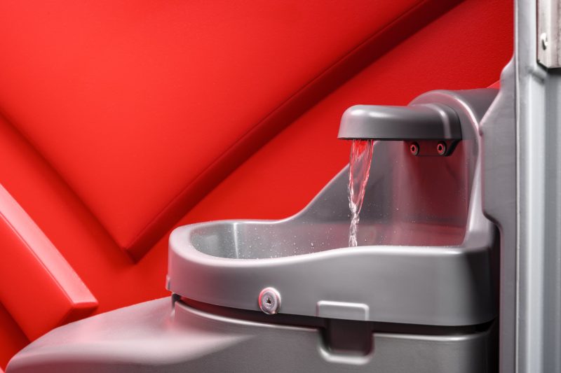 Baustellentoilette mit Handwaschbecken und Seifenspender